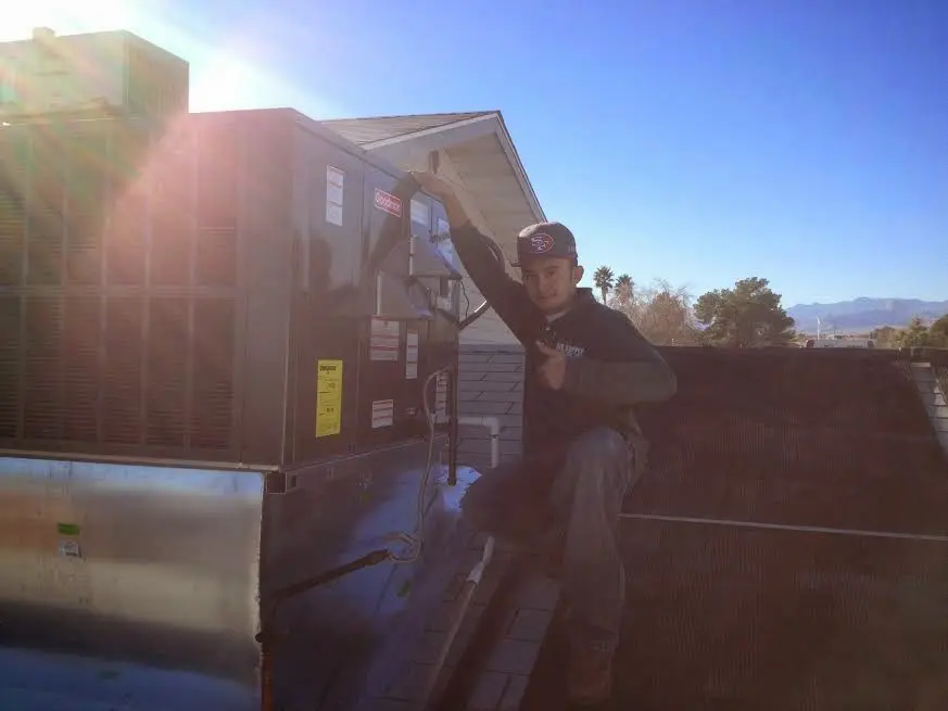 HVAC technician performing HVAC Inspection on a rooftop unit in Barrington